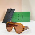 Sunglasses with tortoiseshell frames, amber lenses, and black textured case