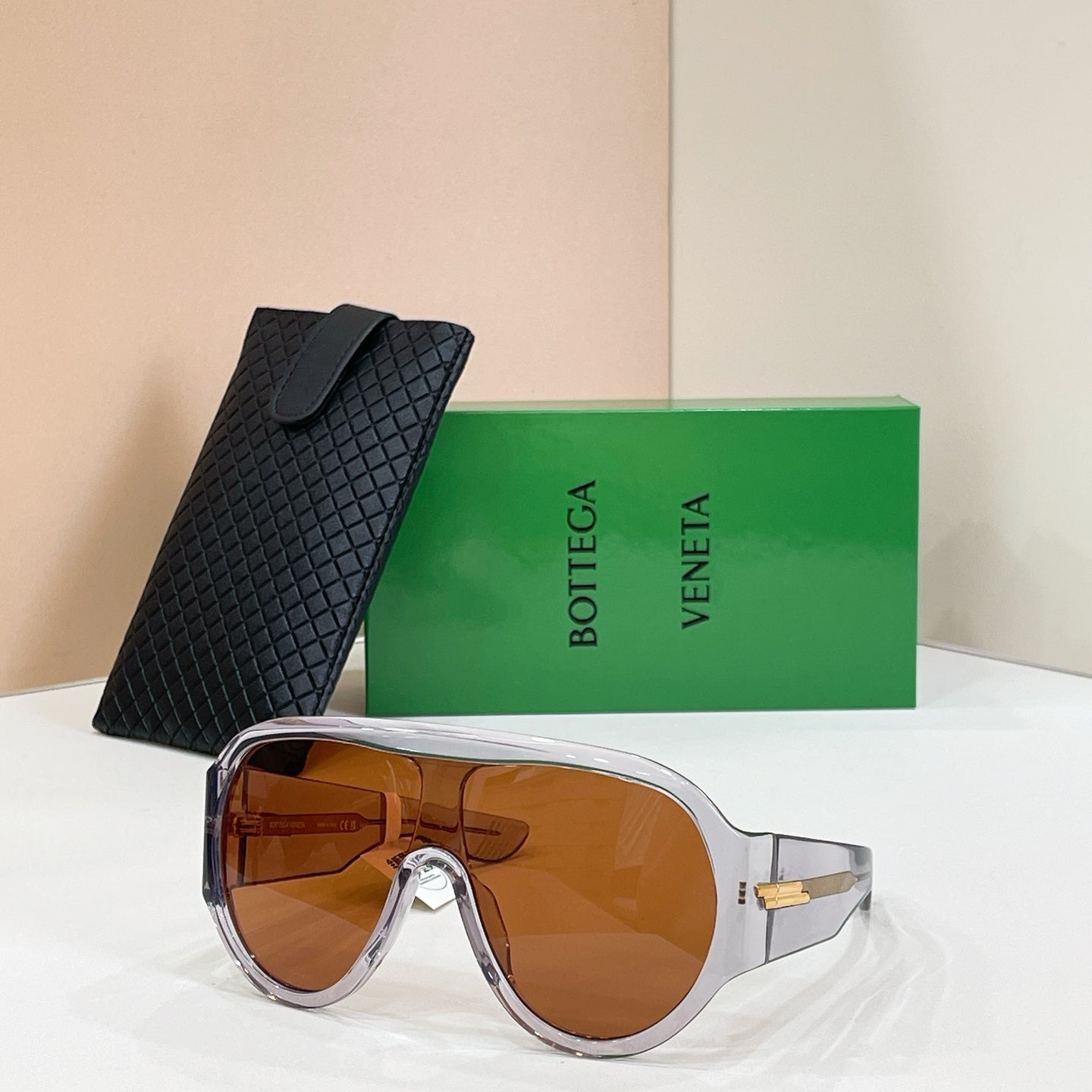 Sunglasses with silver frames and brown lenses, with black textured case
