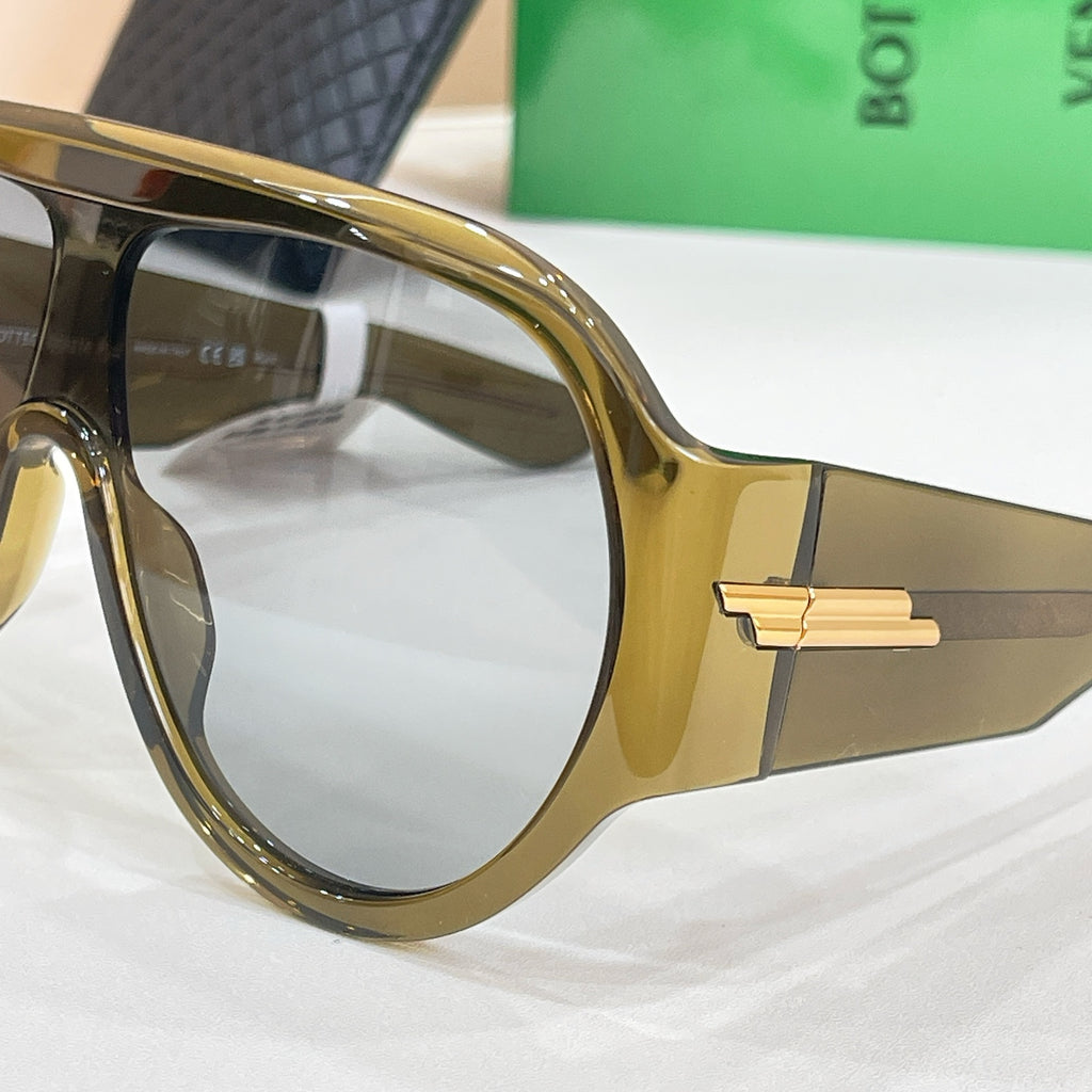 Sunglasses close-up with gold-toned temple and clear-lens frame