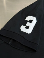 Dark navy polo shirt sleeve with white number 3 applique