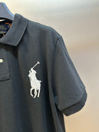 Dark navy polo shirt sleeve with white rider logo