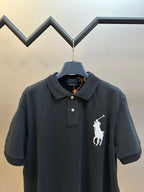 Dark navy polo shirt with collar and white rider logo on chest