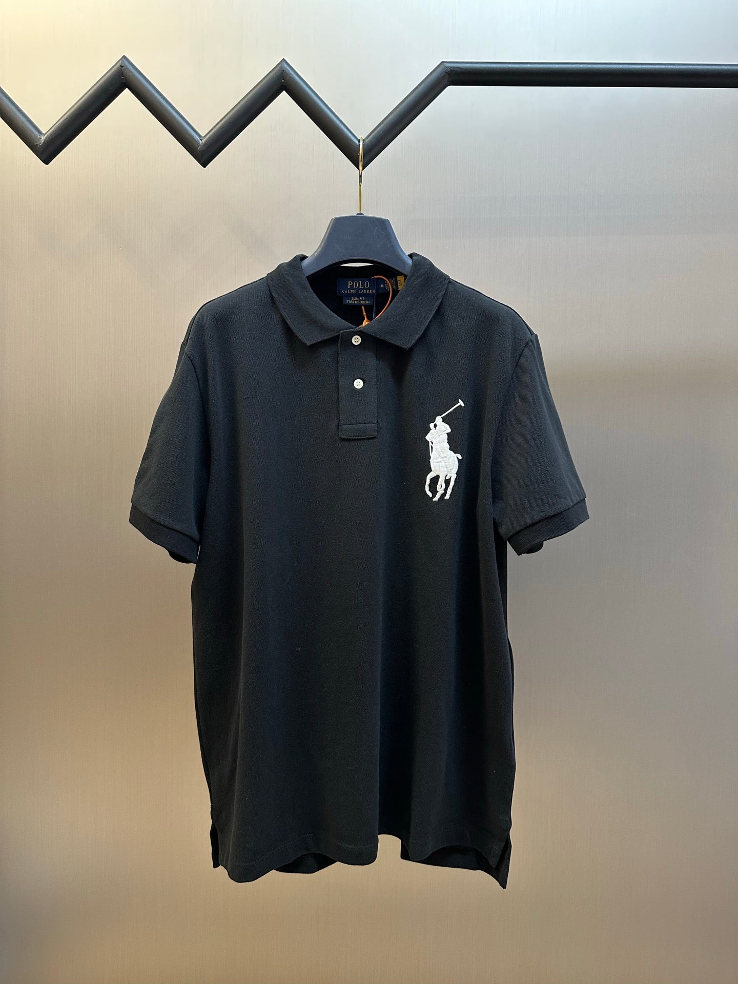 Dark navy polo shirt with button placket and white rider logo