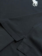 Dark navy polo shirt fabric with crossed seam detail at hem