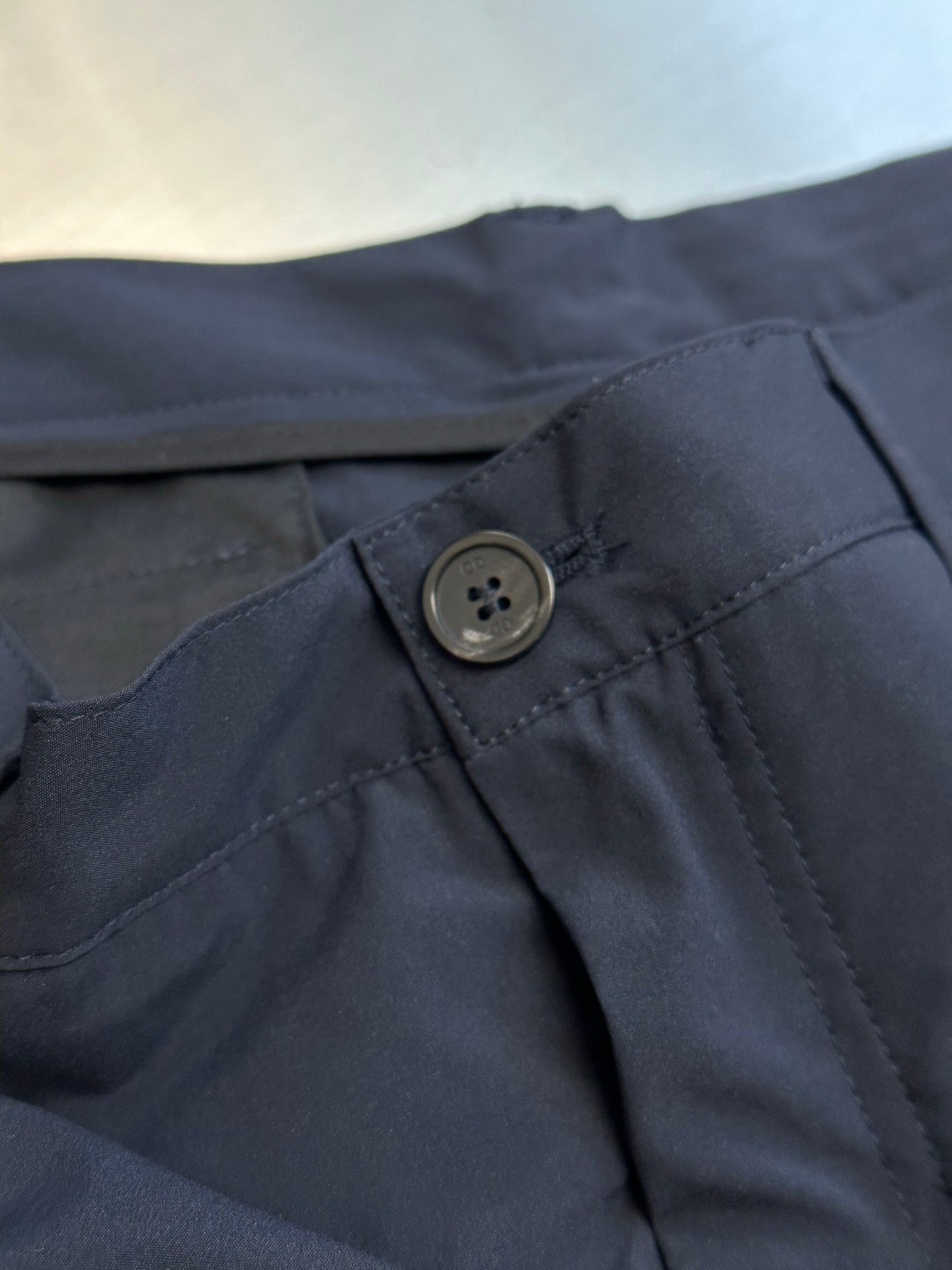 Navy cargo shorts close-up of button closure and stitched front panel