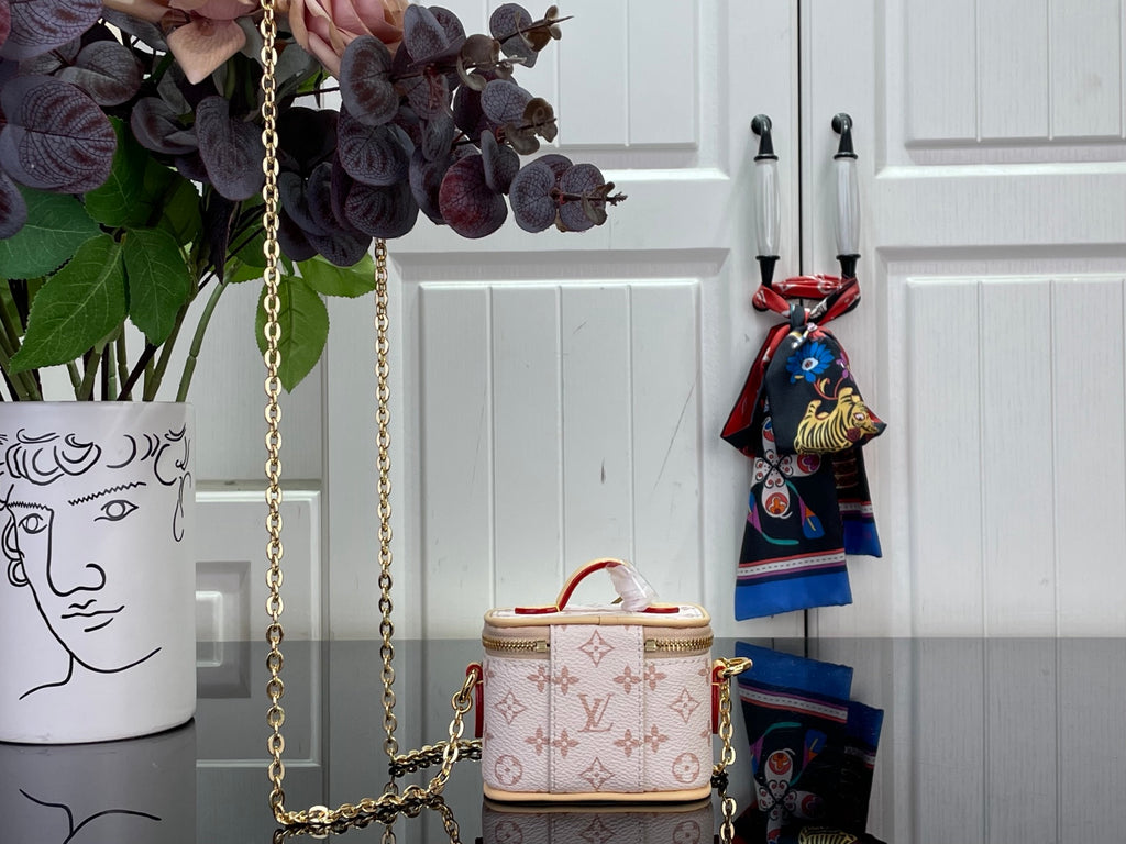 Small monogram mini bag with gold chain crossbody strap and top handle with zipper