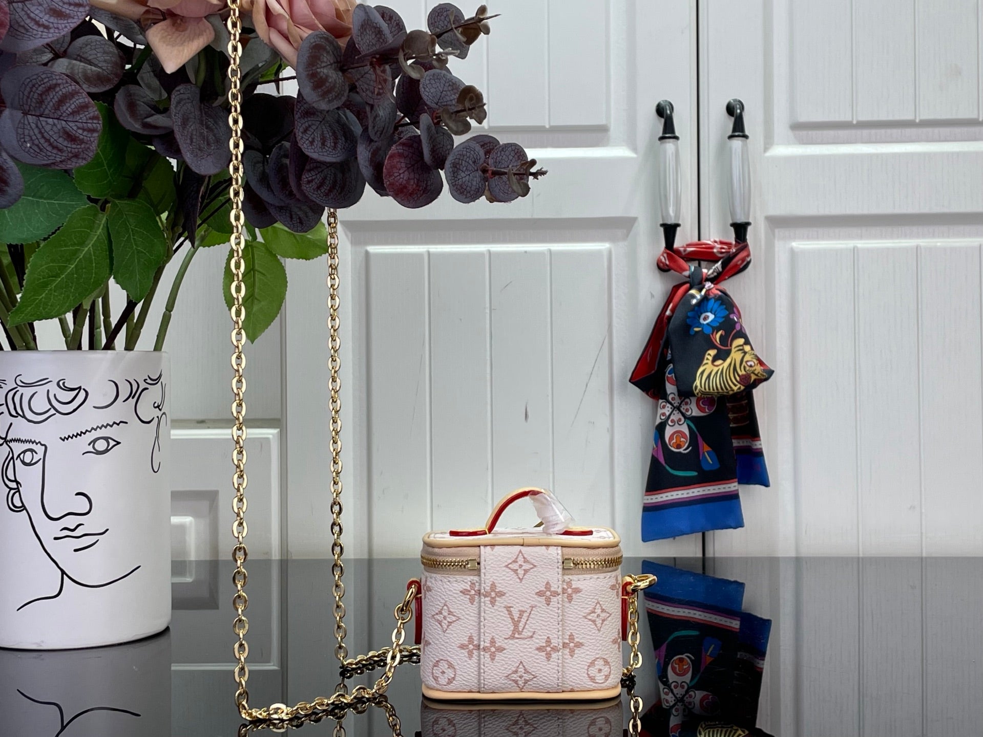Small monogram mini bag with gold chain crossbody strap and top handle with zipper