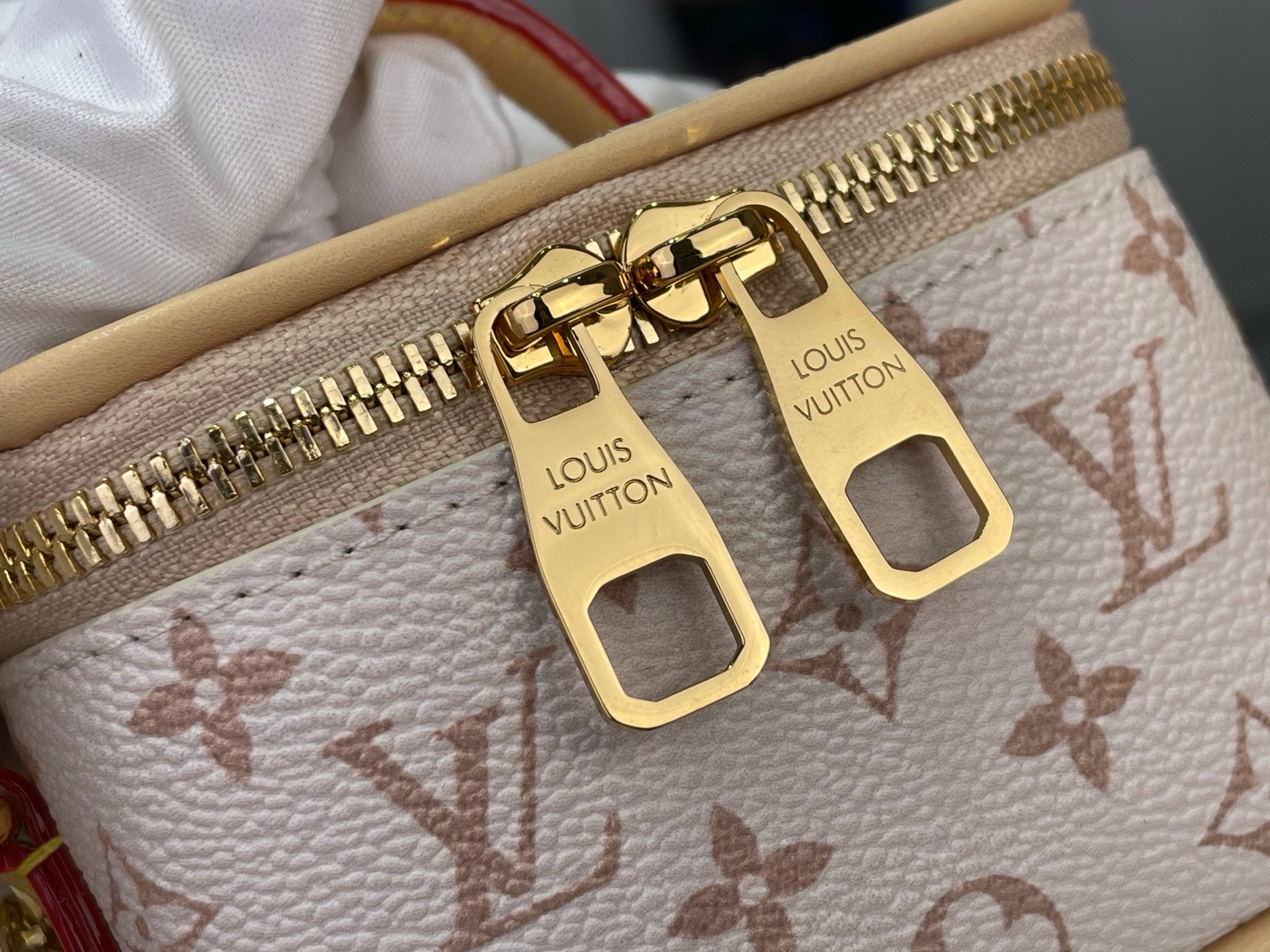Monogram mini bag zipper pulls with gold hardware on white canvas