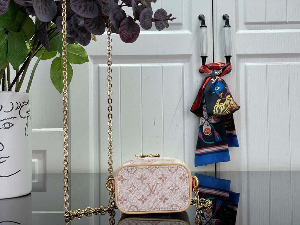 Mini monogram bag with rounded flap front, gold chain strap, and top handle