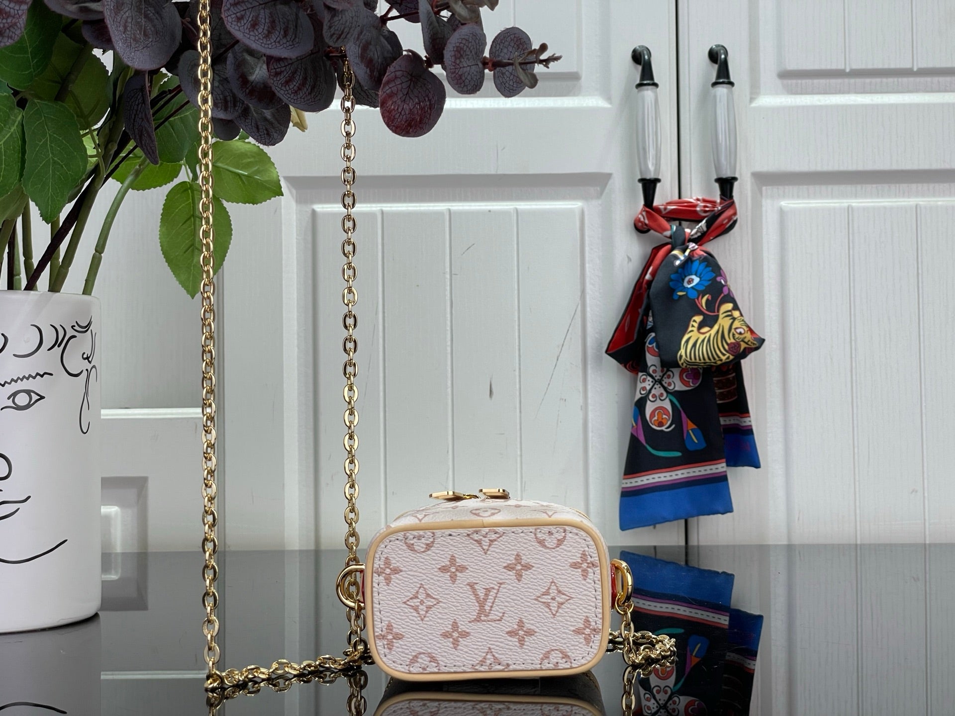 Mini monogram bag with rounded flap front, gold chain strap, and top handle