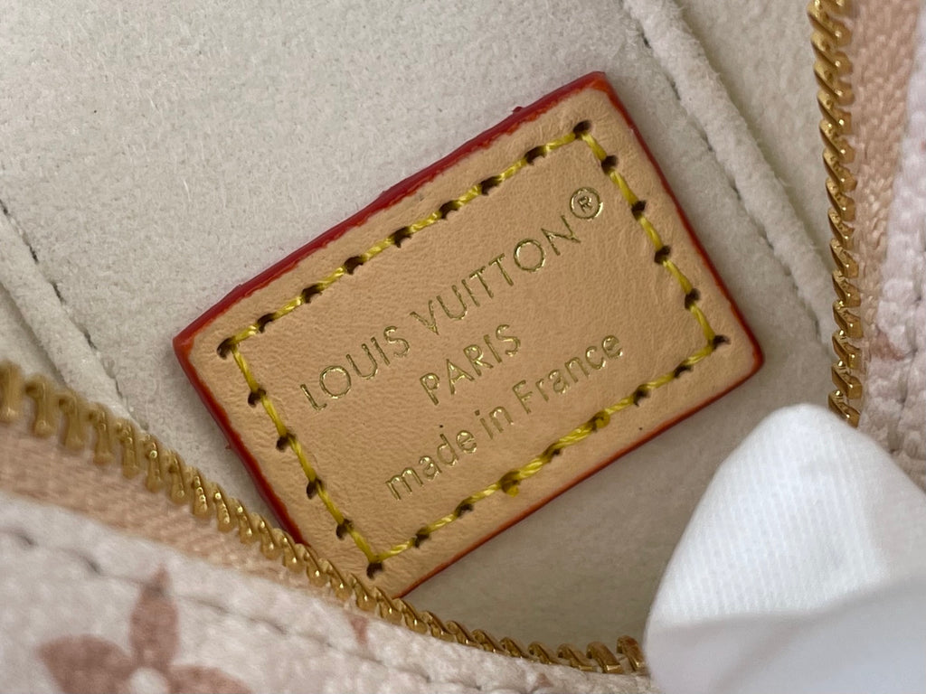 Leather brand label on monogram mini bag lining with 'Louis Vuitton' text