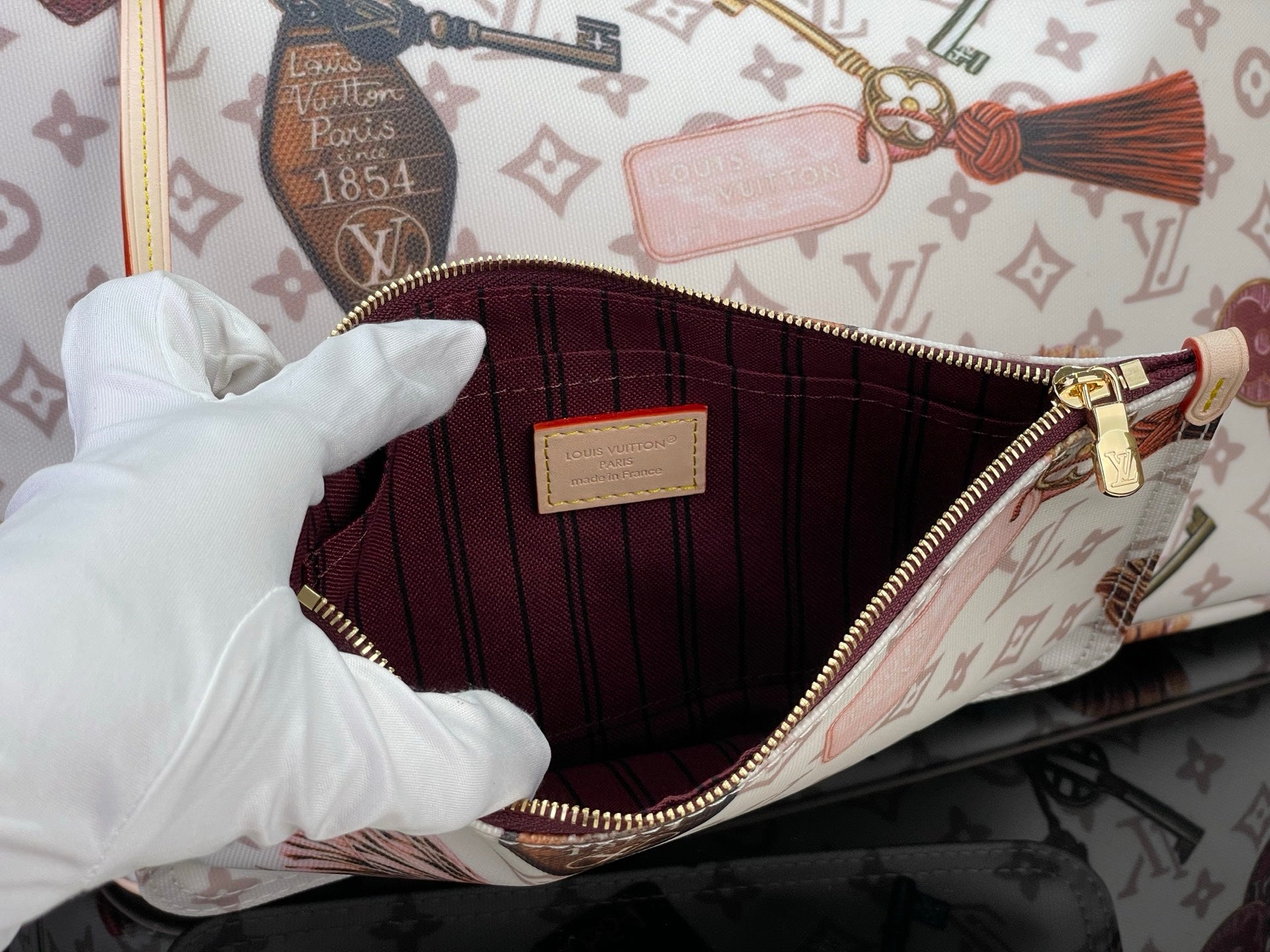 Louis Vuitton tote bag interior with red lining and zipper at the top edge