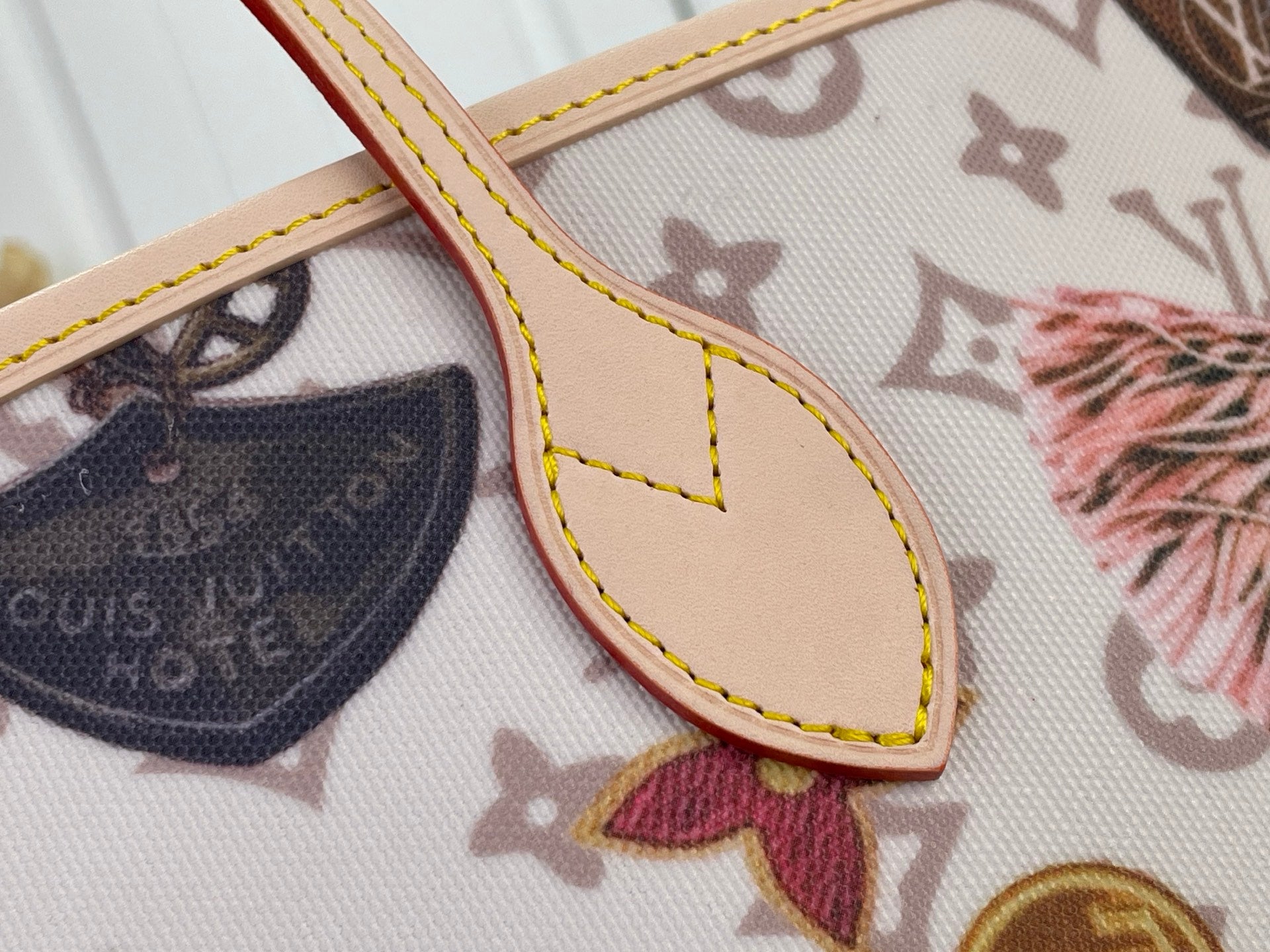 Louis Vuitton tote bag corner detail with tan trim and multicolor print