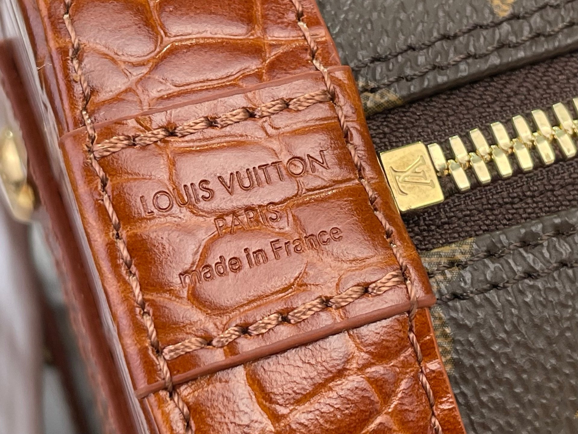 Louis Vuitton brown leather tab with embossed logo and Made in France text