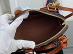 Louis Vuitton monogram pouch bag opened, showing brown interior and gold zipper