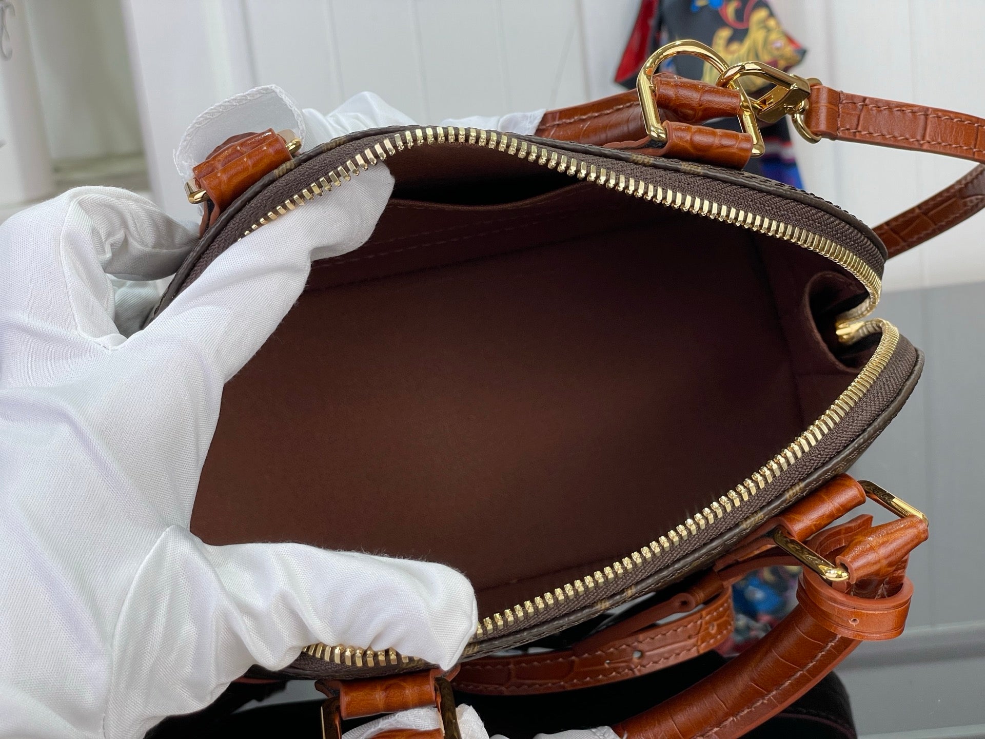 Louis Vuitton monogram pouch bag opened, showing brown interior and gold zipper