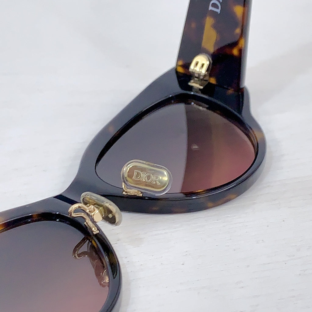 Dior cat-eye sunglasses with tortoiseshell temple tips and tinted lenses close-up