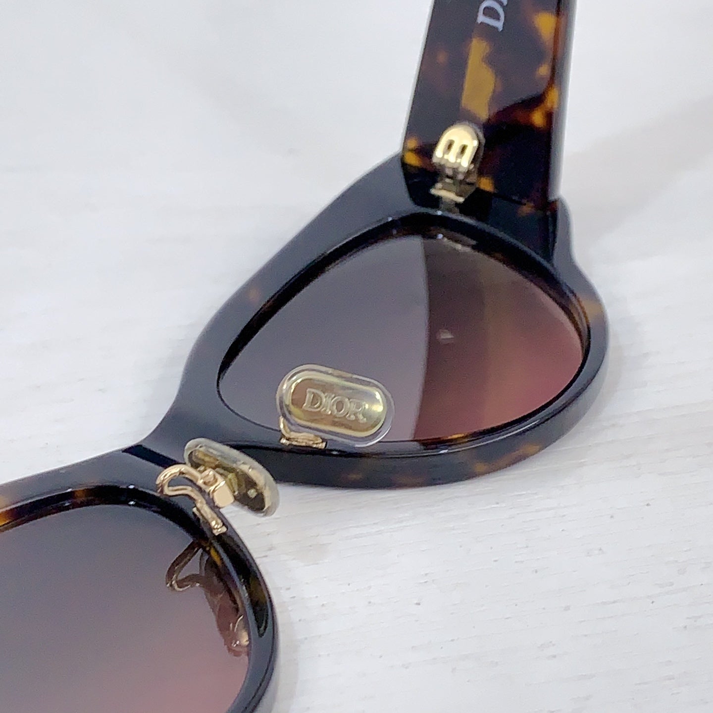 Dior cat-eye sunglasses with tortoiseshell temple tips and tinted lenses close-up