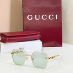 Gucci square sunglasses with gold frame, light blue lenses, and gold-tone chain temples.