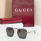 Gucci square sunglasses with black frame and dark lenses, featuring gold-tone chain temples.