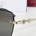 Gucci close-up of gold-tone hinge with GG emblem on black square sunglasses.