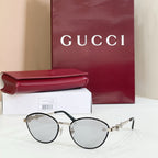 Gucci round sunglasses with light mirrored lenses, black frame, gold accents on arms
