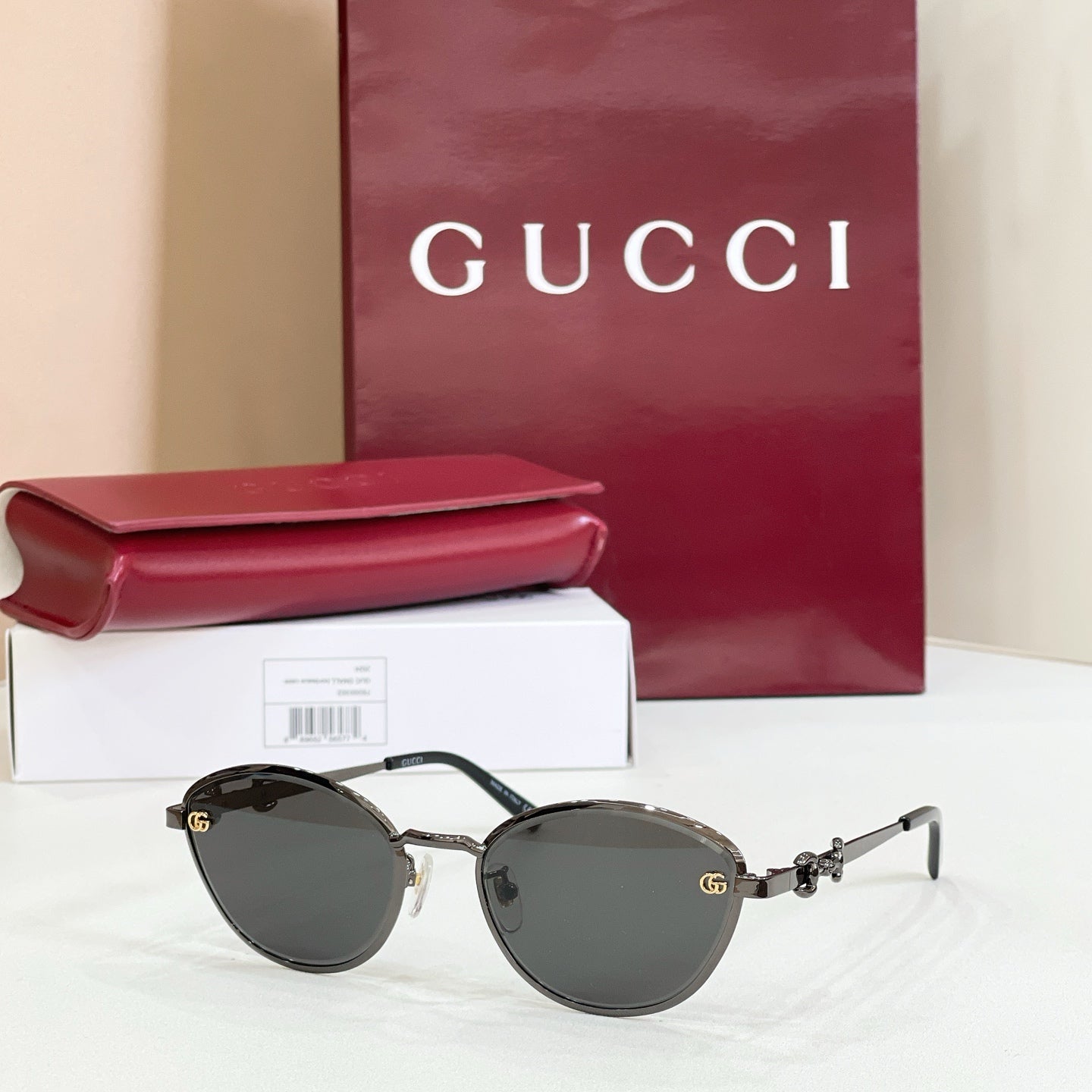 Gucci round sunglasses with dark gray lenses, black-and-silver frame, gold logo details