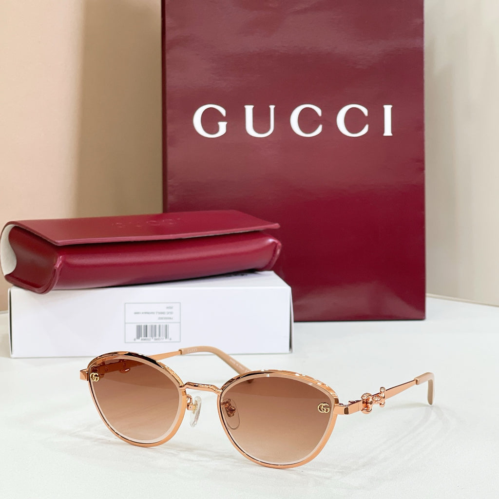 Gucci round sunglasses with brown lenses, gold-tone frame, delicate logo detail on arms