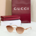 Gucci round sunglasses with brown lenses, gold-tone frame, delicate logo detail on arms