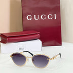 Gucci round sunglasses with purple-tinted lenses, gold-tone frame, logo detail on arms