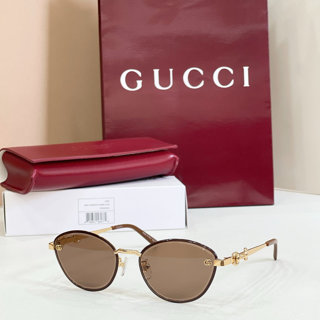 Gucci round sunglasses with brown mirrored lenses, gold-tone frame, logo detail on arms
