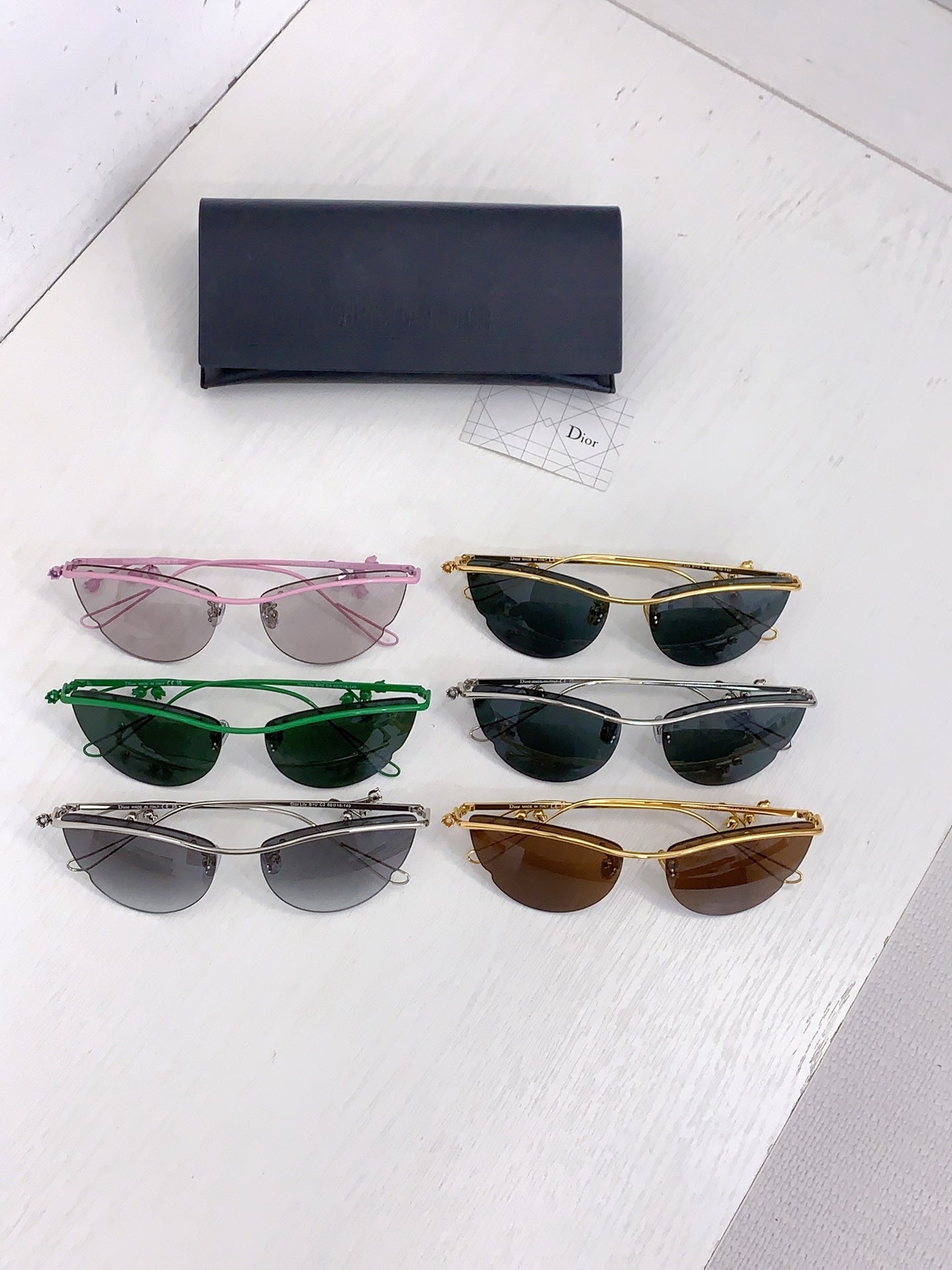 Set of Dior sunglasses in multiple colors with a dark case and cleaning cloth