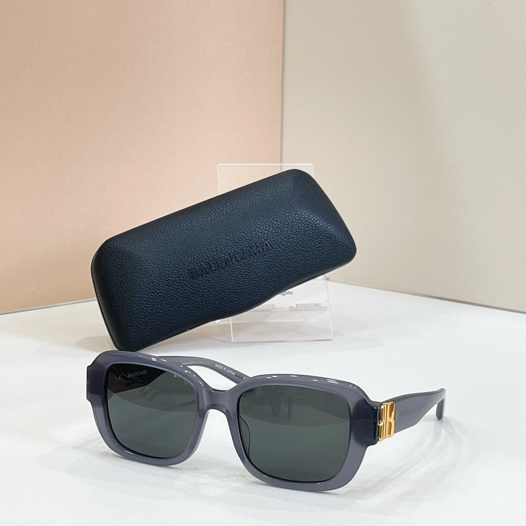 Square sunglasses with gray frames and dark green tinted lenses, gold hinge detail