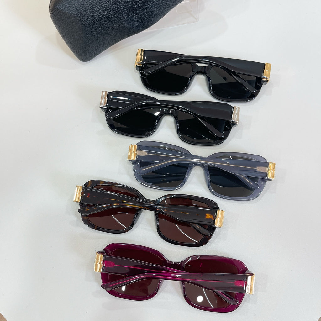 Stacked square sunglasses set with gold hinges and assorted tinted lenses