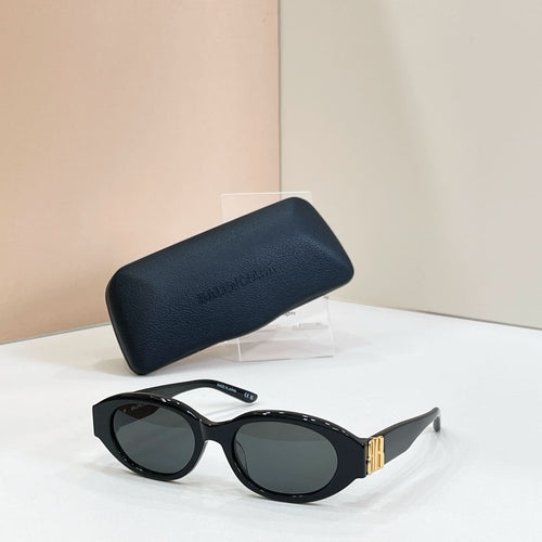 Balenciaga sunglasses with black frames and dark lenses, resting on dark case