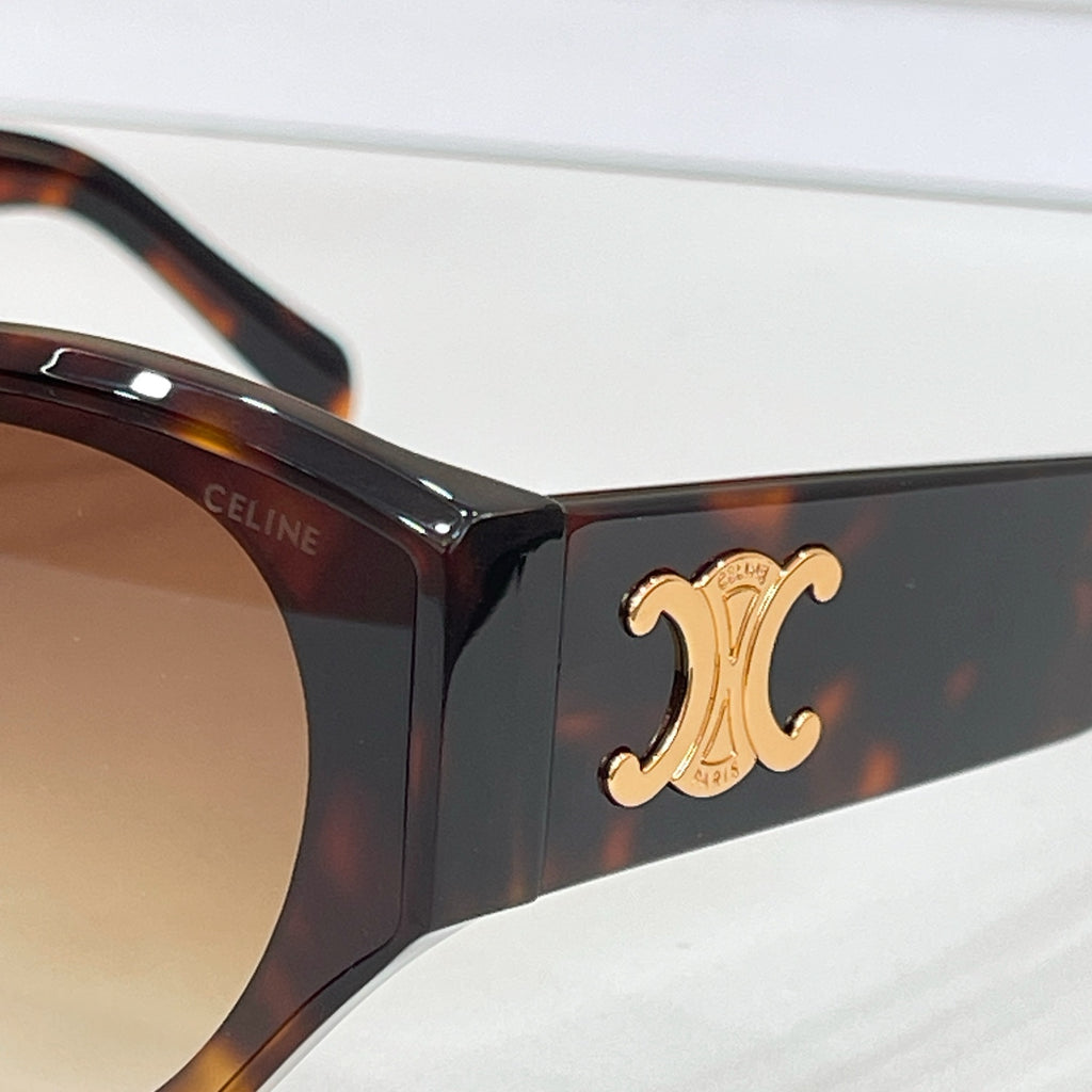 Close-up of dark Celine sunglasses with gold C logo on the temple