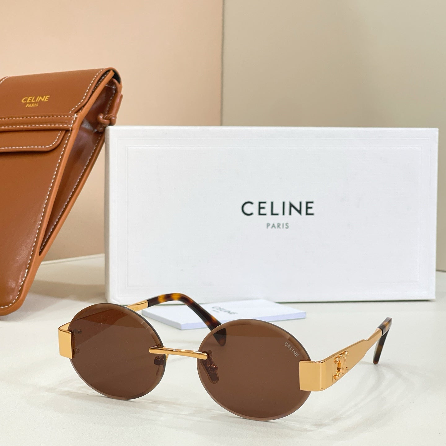 Gold-tone round sunglasses with dark brown lenses and tortoiseshell temples