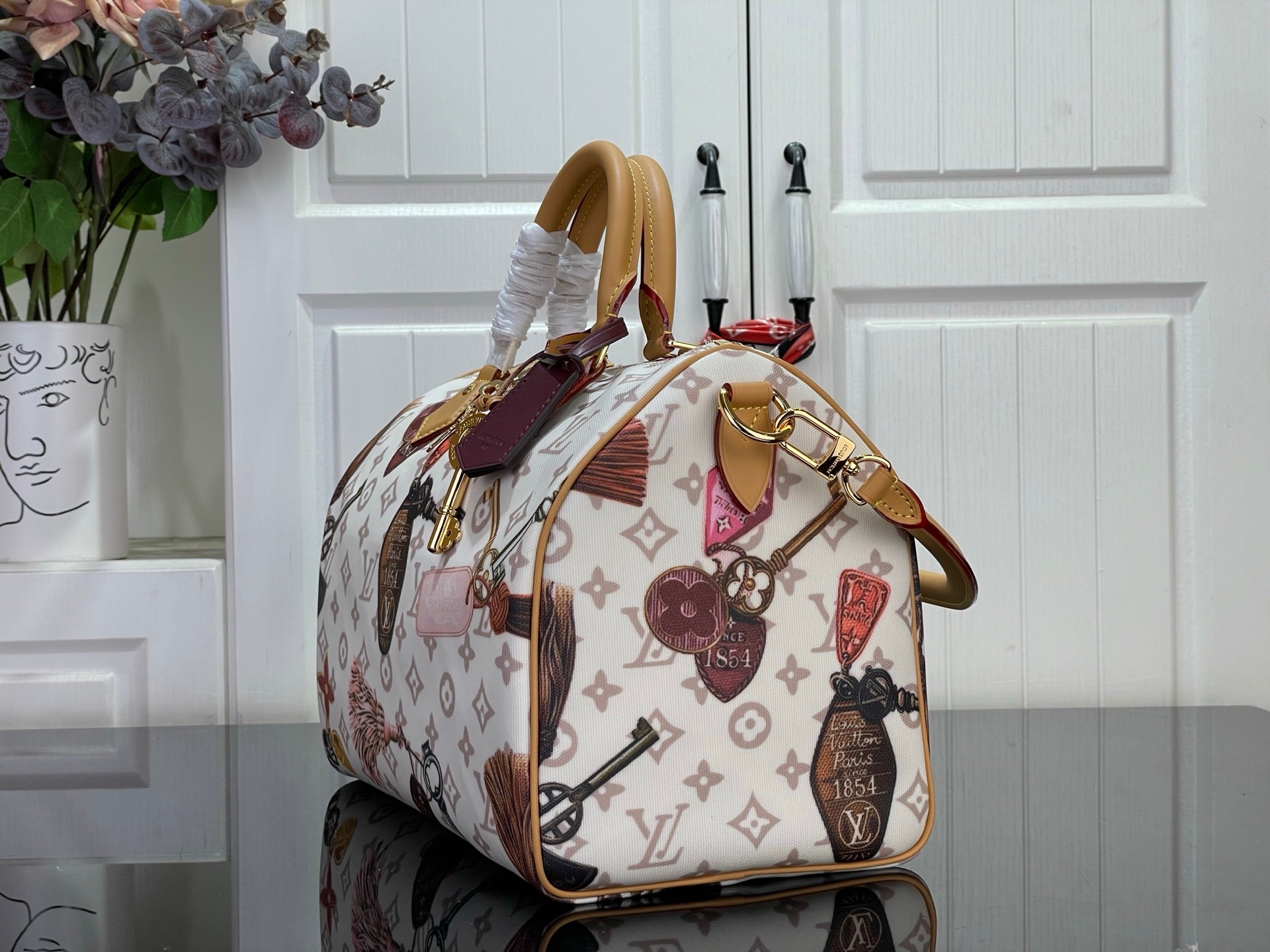 Louis Vuitton monogram tote handbag with side handles and multiple attached charms