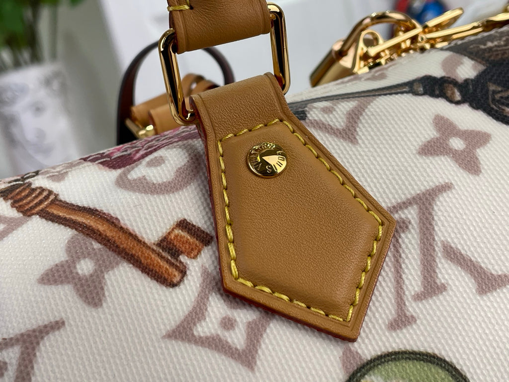 Louis Vuitton leather tab charm on monogram handbag strap with gold logo medallion