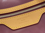 Louis Vuitton bag close-up of yellow trim, zipper, and embossed logo on leather