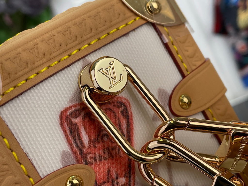 Louis Vuitton medallion clasp with gold-tone ring hardware on tan leather strap