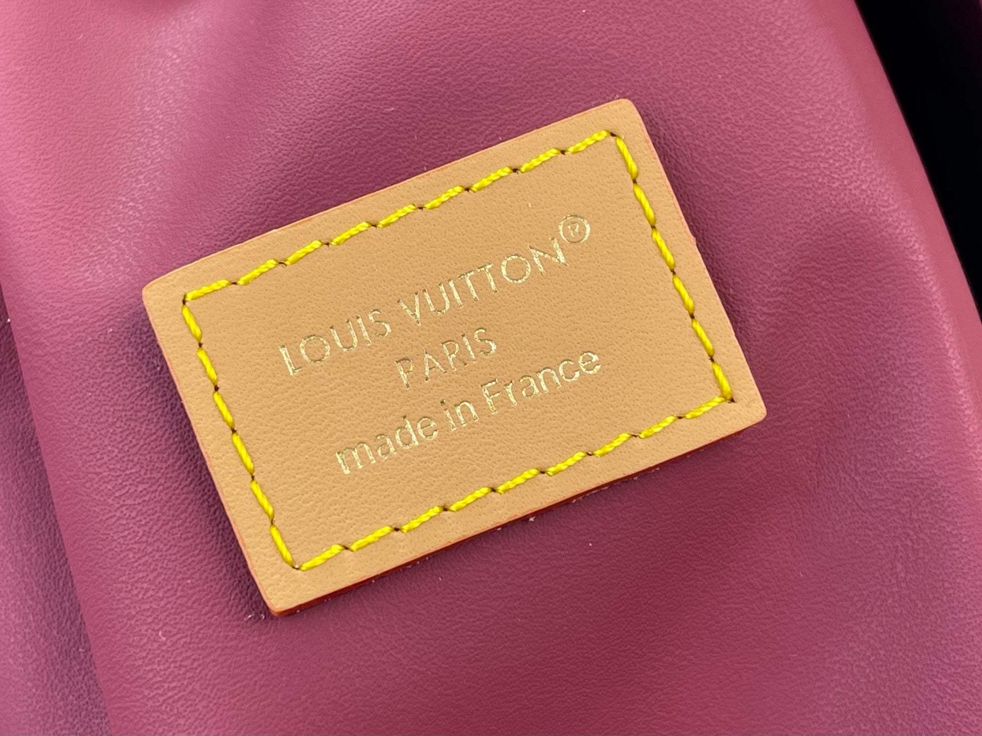 Louis Vuitton bag: pink leather with tan logo patch and yellow-stitched edge label