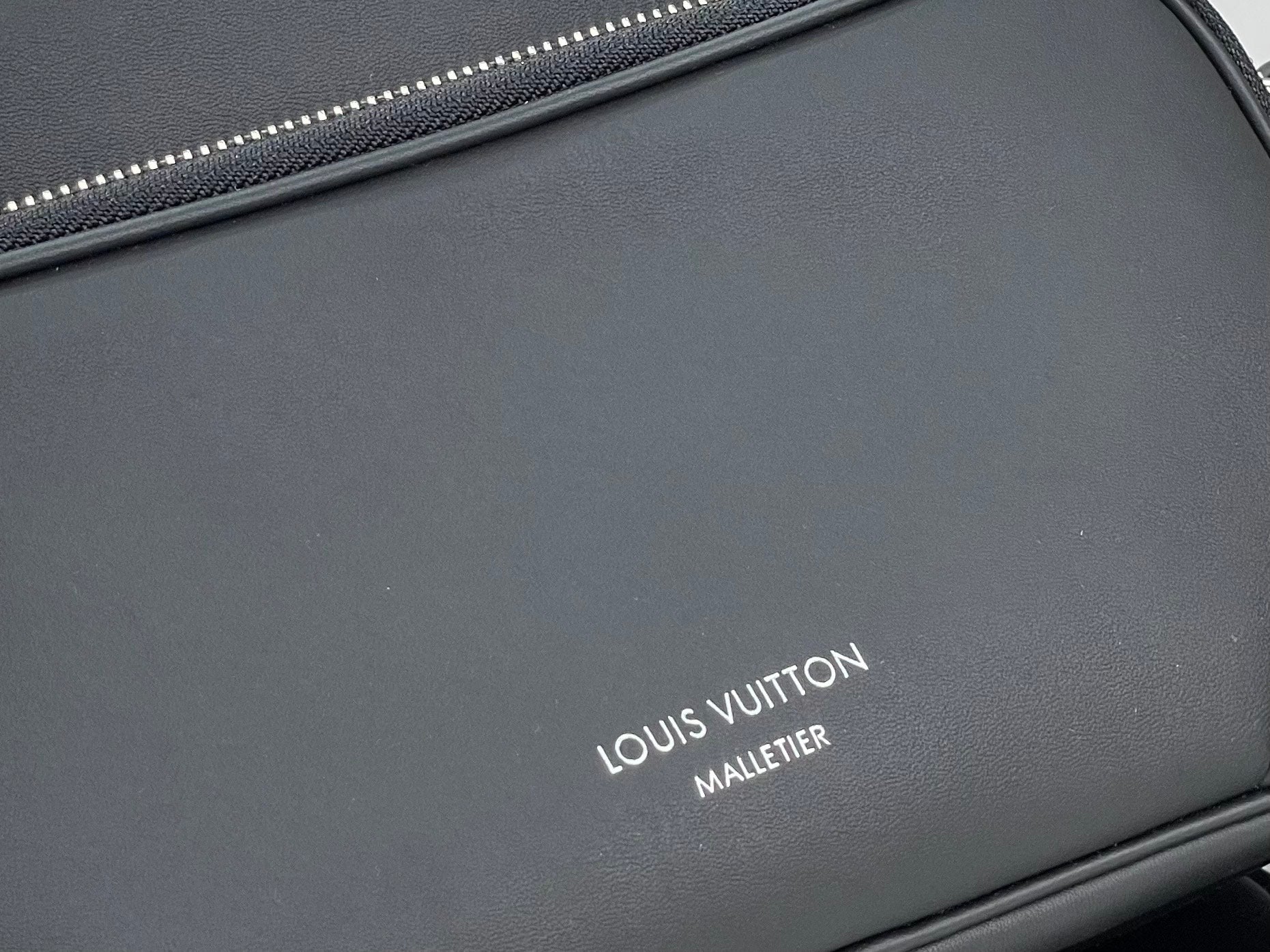 Louis Vuitton “MALETIER” logo on dark black leather bag front panel