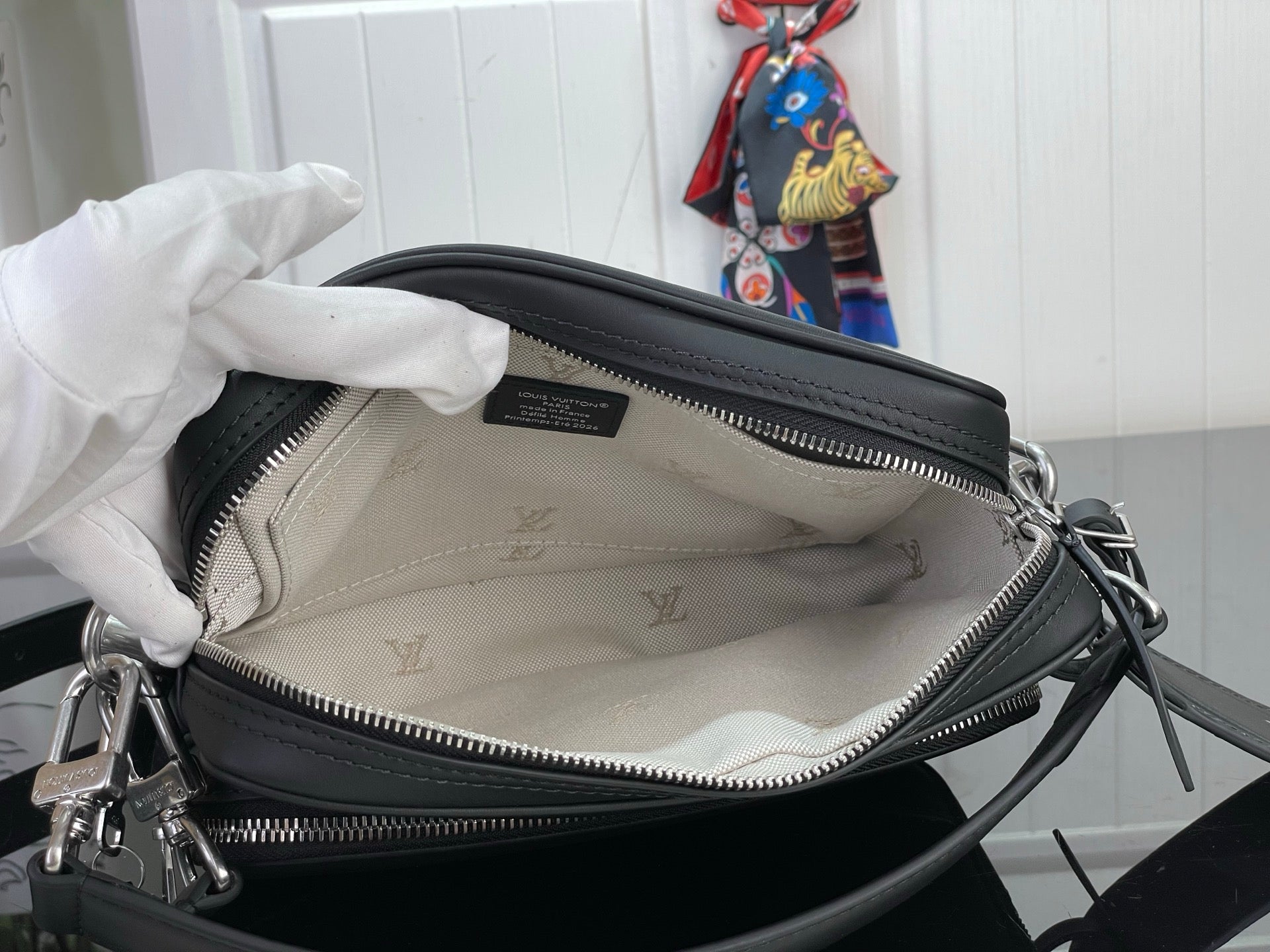Black handbag with zipper opening and light logo-lined interior
