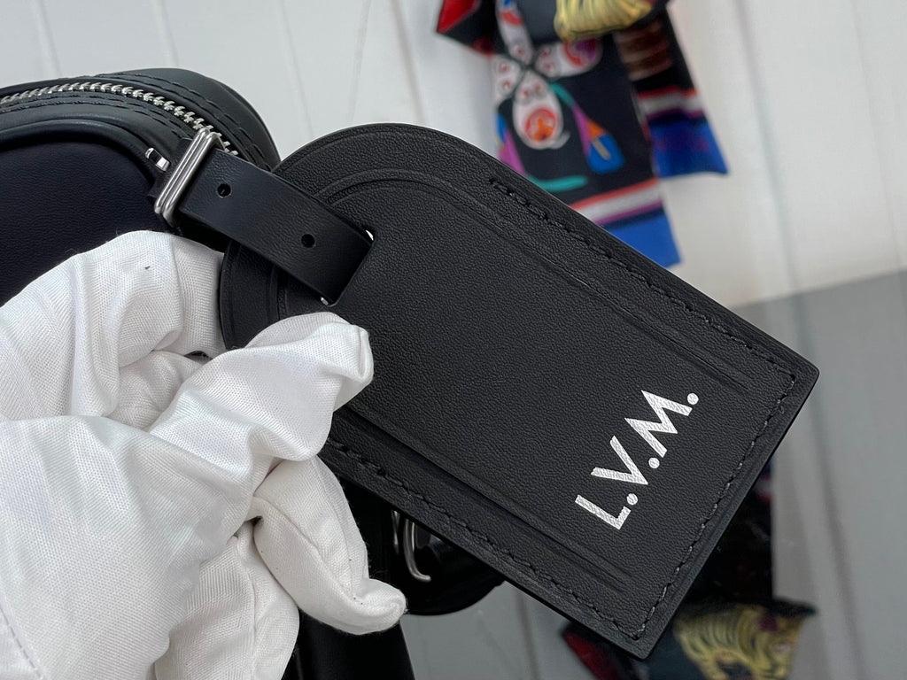 Louis Vuitton leather strap tag with “L.V.M.” lettering and grommet holes
