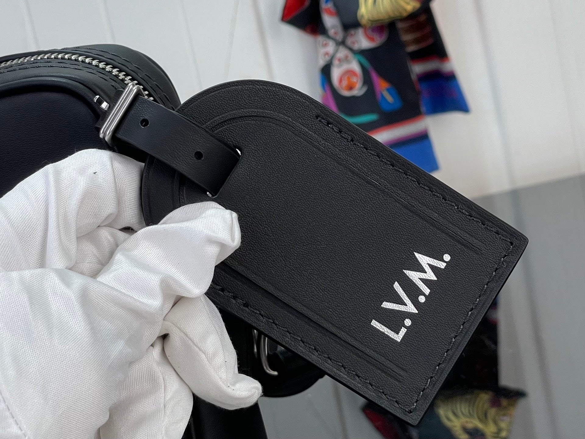 Louis Vuitton leather strap tag with “L.V.M.” lettering and grommet holes