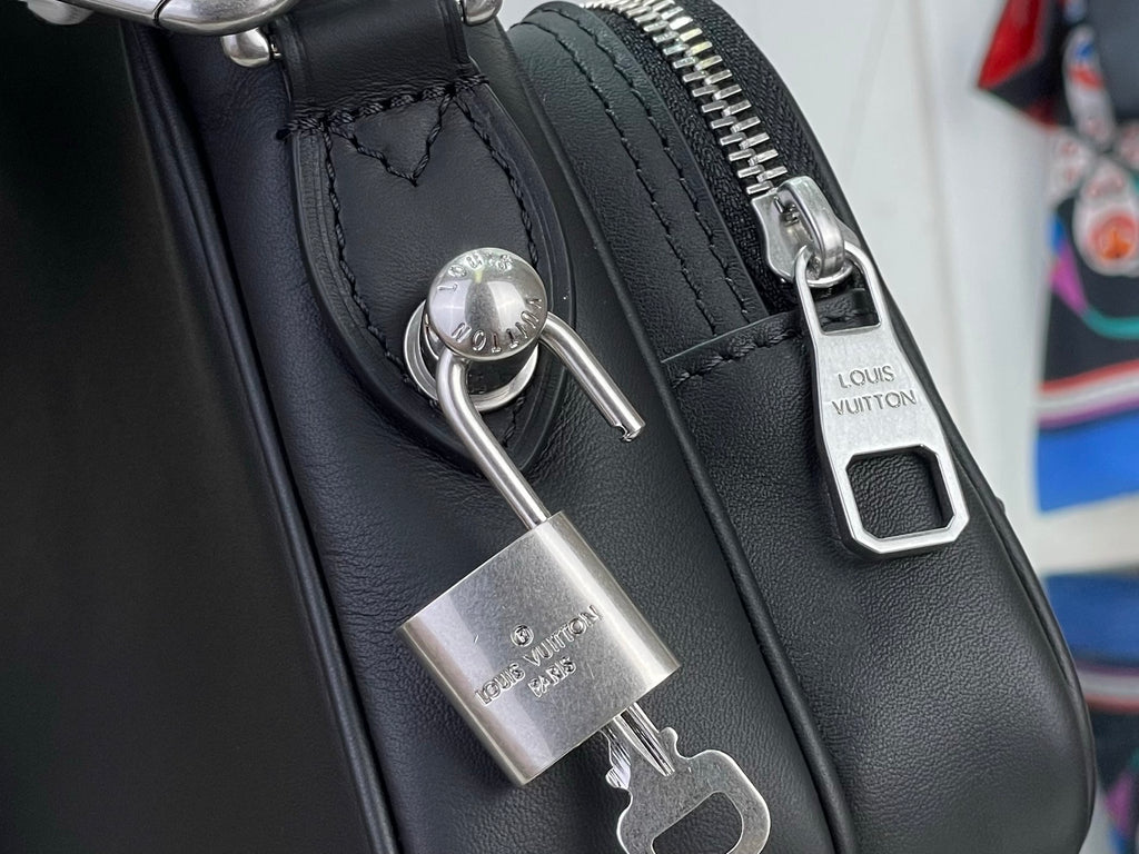 Louis Vuitton crossbody bag close-up of padlock and silver zipper pull hardware