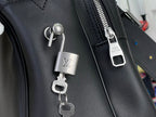 Louis Vuitton bag lock charm and metal zipper pull on dark leather