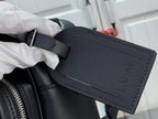 Dark leather bag pocket with strap and embossed LV pattern on front.