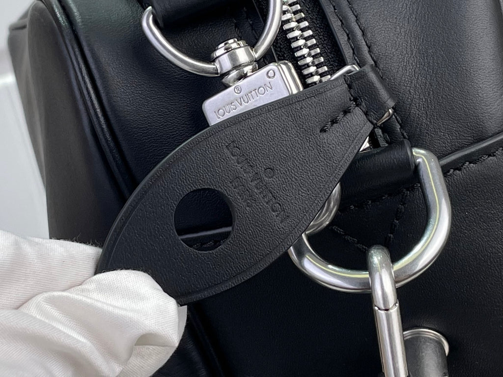 Leather strap attachment with silver hardware and Louis Vuitton Maullertine tag.
